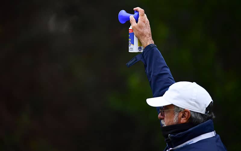 A USGA official blows the horn to signal a weather delay during the final round at the 2020 U.S. Women's Open at Champions Golf Club (Cypress Creek Course) in Houston, Texas on Sunday, Dec. 13, 2020. (Robert Beck/USGA)